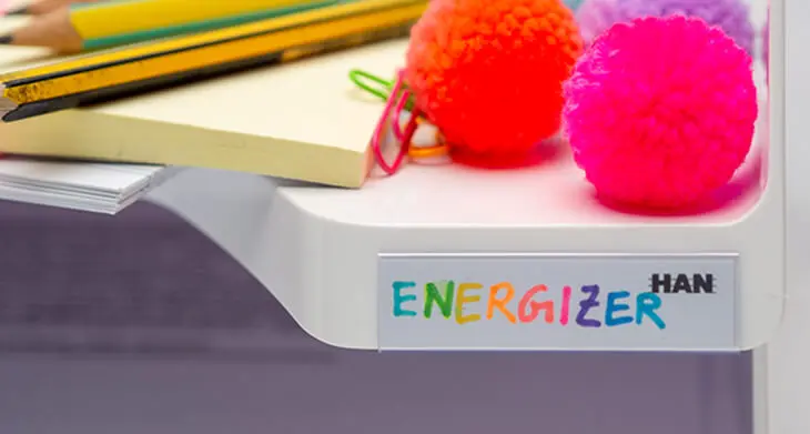 Weiße Schreibtischablage von HAN. Auf dem Reiter steht „Energizer“ in bunten Buchstaben. Obendrauf liegen Materialien für Energizer-Spiele in Meetings. Foto: Johanna Rundel