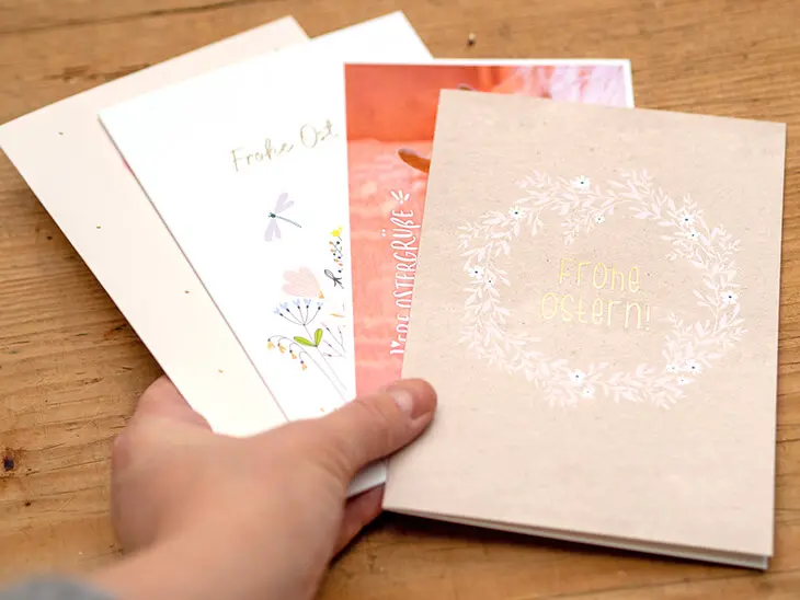 Jemand hält verschiedene Osterkarten von Grafik Werkstatt aufgefächert ins Bild. Foto: Johanna Rundel