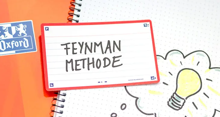 Eine Karteikarte mit rotem Rand liegt auf einem orangefarbenen Collegeblock von Oxford. Darauf steht in großen, schwarzen Buchstaben „Feynman Methode“. Foto: Johanna Rundel