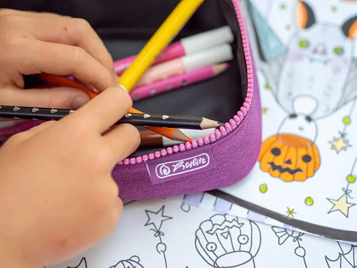 Kind wühlt durch Pelikan Stifte in pinkem herlitz-Mäppchen. Foto: Johanna Rundel