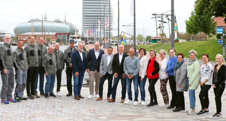 Mitarbeiter der Firma Doescher stehen draußen und schauen in die Kamera