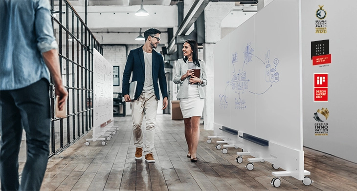 Zwei Kollegen im Gespräch neben magnetoplan® Infinity Walls.