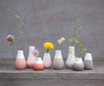 Blumenvasen auf einem Holzbrett.