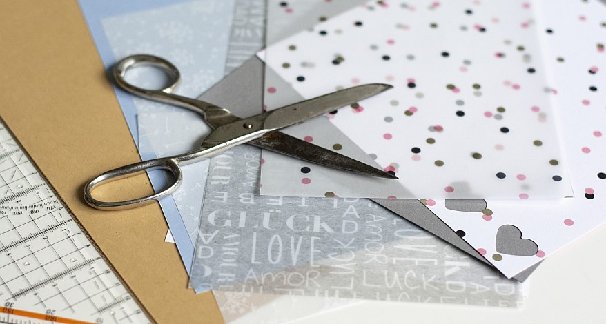 Papier und Schere auf Tisch zum Basteln von Bestecktaschen