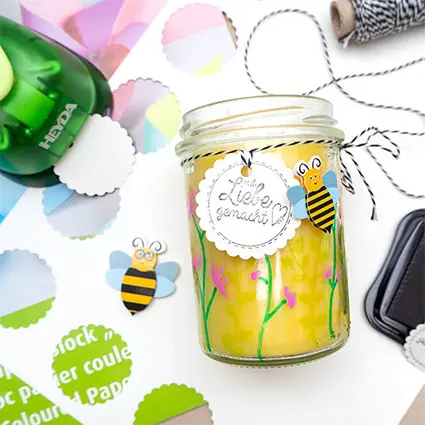 Eine aus Bienenwachs gegossene Kerze im Glas auf einem weißen Blatt Papier. Foto: Johanna Rundel