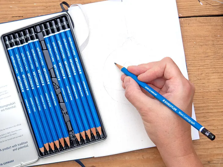 Jemand zeichnet mit einem STAEDTLER-Bleistift eine Vorlage in ein BuJo. Foto: Johanna Rundel