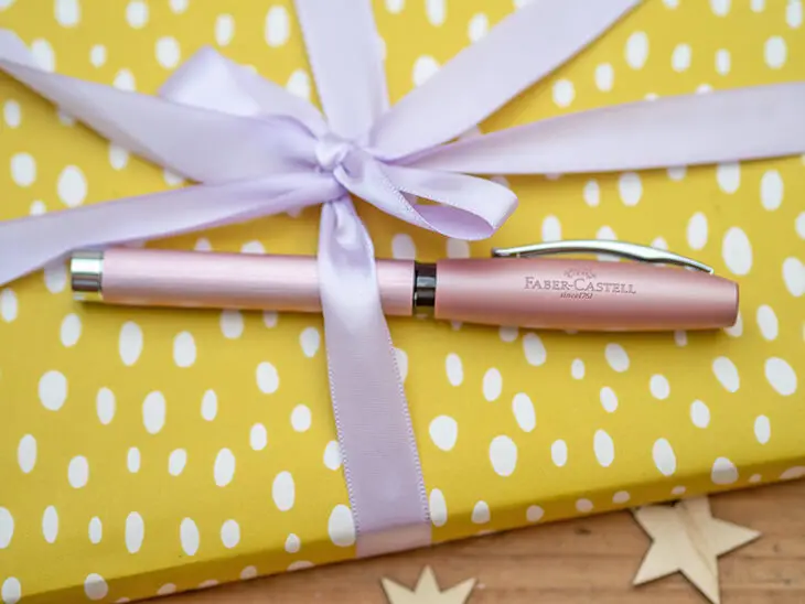 Rosa Füller von Faber-Castell liegt auf einem gelben Geschenk. Foto: Johanna Rundel