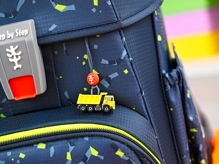 Dunkelblauer Schulranzen mit Konfettimuster von Step by Step mit gelbem LKW-Anhänger.