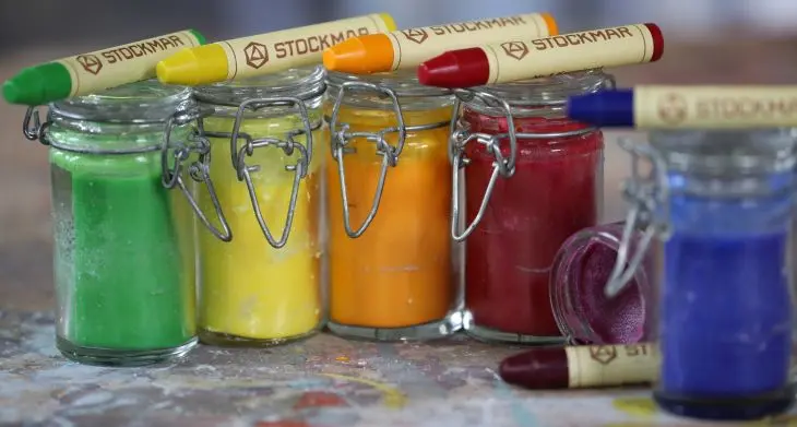 Kleine Weckgläser mit bunter Knete stehen beieinander, auf ihnen liegen bunte Wachsmalstifte von STOCKMAR