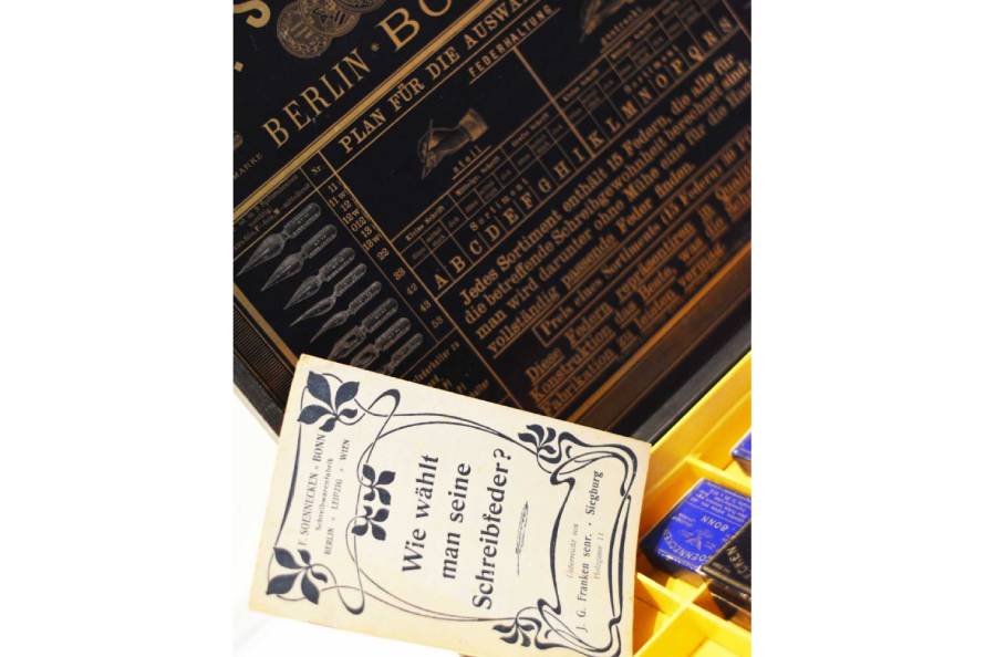 Alte Anleitung zur Auswahl von Schreibfedern vor schwarzer Musterbox.