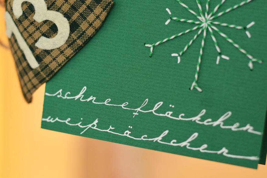 Grüne Karte mit gestickter Schneeflocke und Handschrift