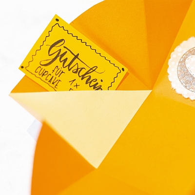 Gutschein für einen Cupcake in einer Explosionsbox.