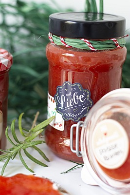 Nahaufnahme eines beschrifteten Marmeladenglases mit „Mit Liebe“-Etikett.