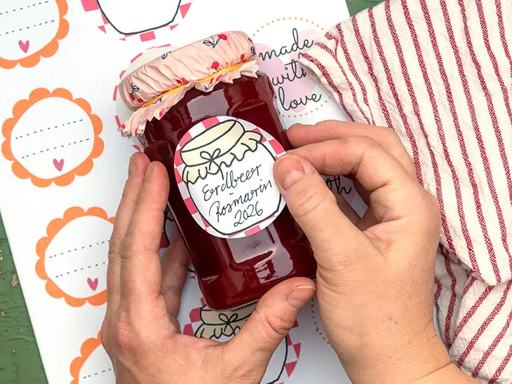 Jemand klebt ein Etikett von Avery Zweckform auf ein Marmeladenglas. Foto: Johanna Rundel