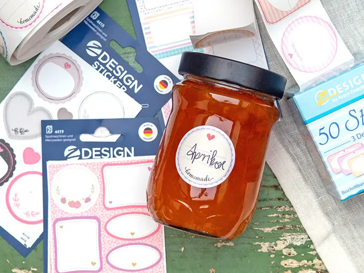 Ein Marmeladenglas liegt zwischen verschiedenen Aufklebern von Avery Zweckform. Foto: Johanna Rundel