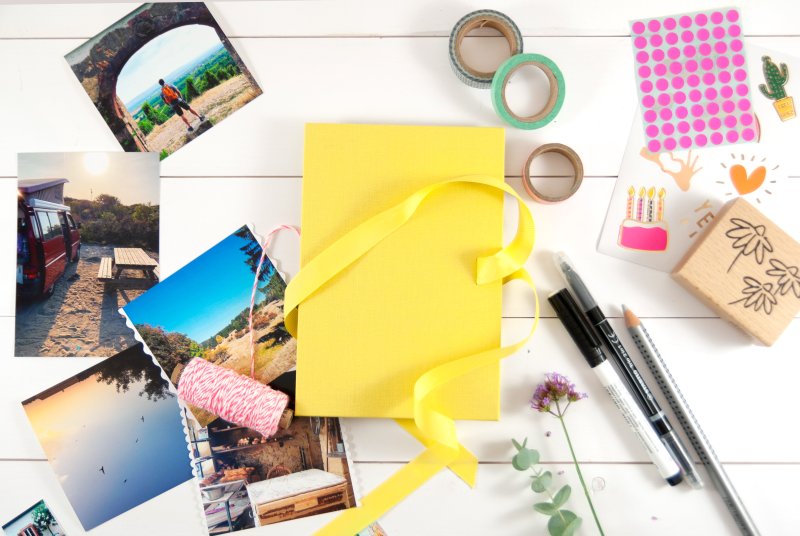 Gelbes Leporello mit Bastelmaterialien und Urlaubsfotos