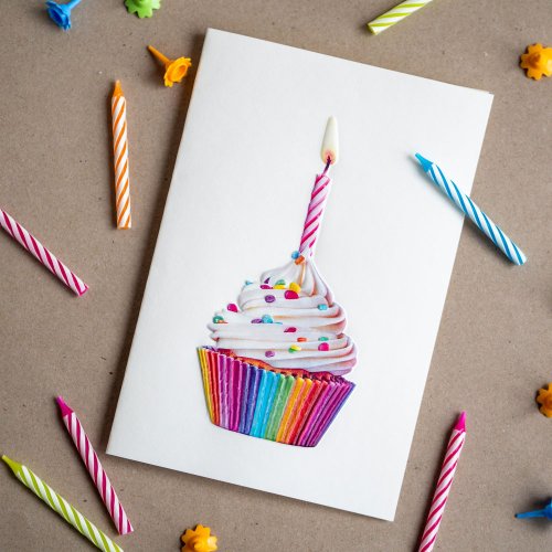 Geburtstagskarte mit buntem Cupcake, kleine Geburtstagskerzen daneben