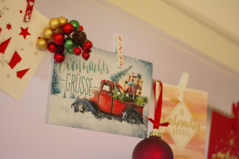 Nahaufnahme von Weihnachtskarte an einer Girladen mit kleinen Weihnachtskugeln