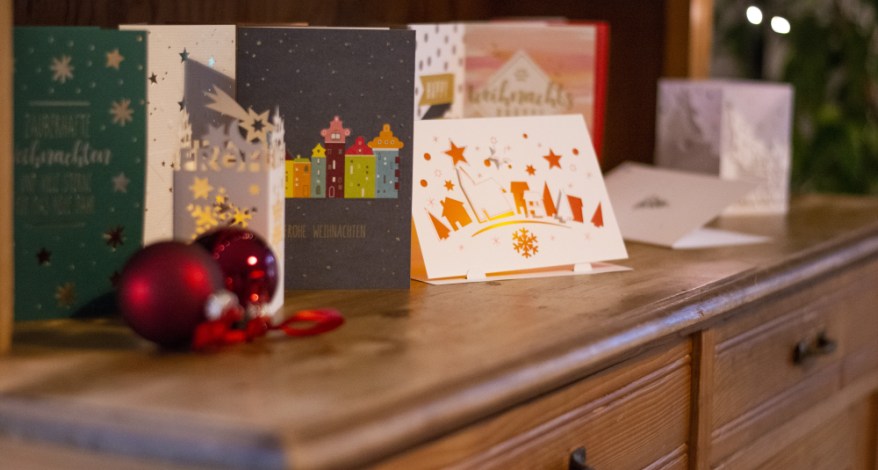 Verschiedene Weihnachtskarten stehen dekorativ auf einer Holzkommode