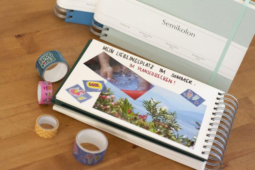 Ein Trostalbum für Kindergartenkinder: Eingeklebt sind zwei Fotos: Eine Nahaufnahme von einem badenden Kind im Planschbecken, eine Sommerlandschaft. Verziert wurden die Bilder mit buntem Maskingtape.