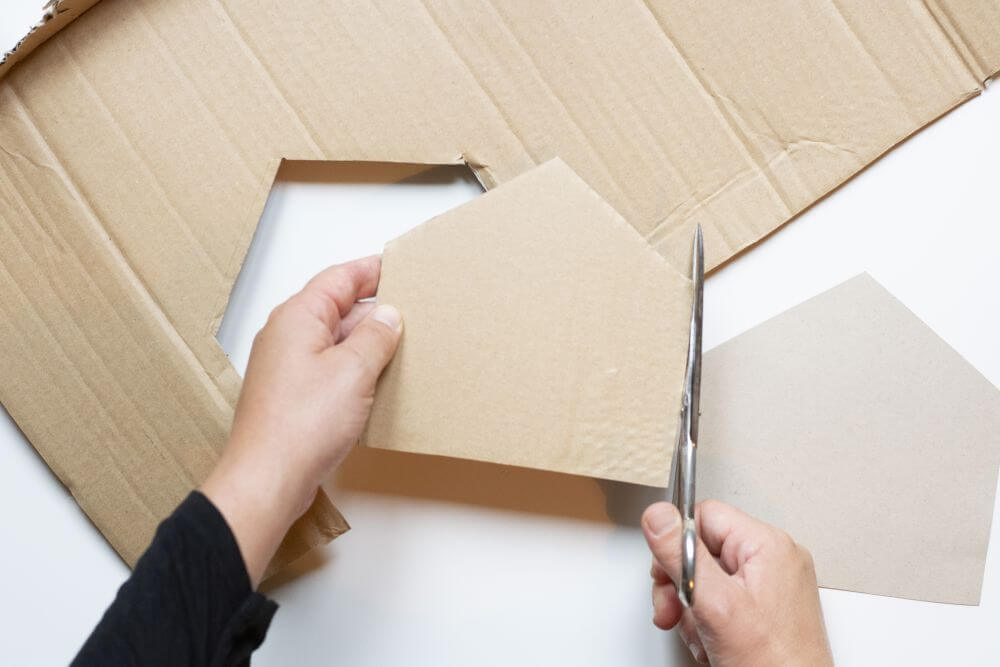 Wichteltür zu Weihnachten basteln, Bastelanleitung Schritt 2: Den Hausumriss auf einem Stück Pappe nachfahren, ausschneiden und so den Bastelkarton verstärken.
