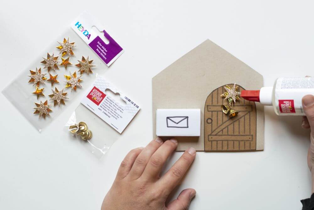 Wichteltür zu Weihnachten basteln, Bastelanleitung Schritt 5: Das Wichtelhaus mit Dekostickern und Glöckchen von Heyda dekorieren.