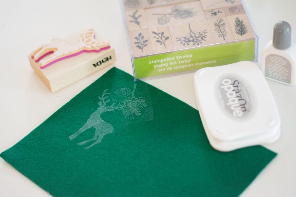 Nahaufnahme eines Hirschs, der als Stempel von der Marke Heyda mit Hilfe von Staz'On-Stempelfarbe auf ein Stück grünen Filzstoff gestempelt wurde.