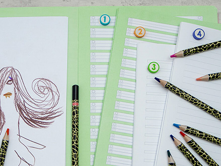 Auf einem hellen Untergrund liegen vier aufgeschlagene Geschichtenhefte von Brunnen mit Lineaturen für die erste bis vierte Klasse. Auf dem linken Heft ist eine Kinderzeichnung zu sehen. Außerdem liegen viele Buntstifte auf den Heften. Foto: Johanna Rundel