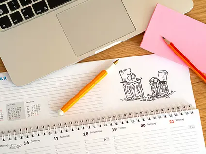 Auf einem Schreibtisch liegt ein Tischkalender vom Athesia Kalenderverlag mit Motiven des Comics "Simons Cat". Drumherum sind typische Büroutensilien verteilt. Foto: Johanna Rundel