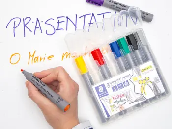 Jemand schreibt mit Flipchart-Markern von STAEDTLER Texte auf ein großes Blatt Papier. Foto: Johanna Rundel
