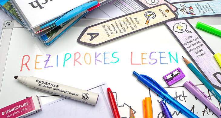 Auf ein Whiteboard wurde mit Markern von STAEDTLER in bunten Buchstaben „reziprokes Lesen“ geschrieben. Darum herum liegen verschiedene Schulmaterialien. Foto: Johanna Rundel
