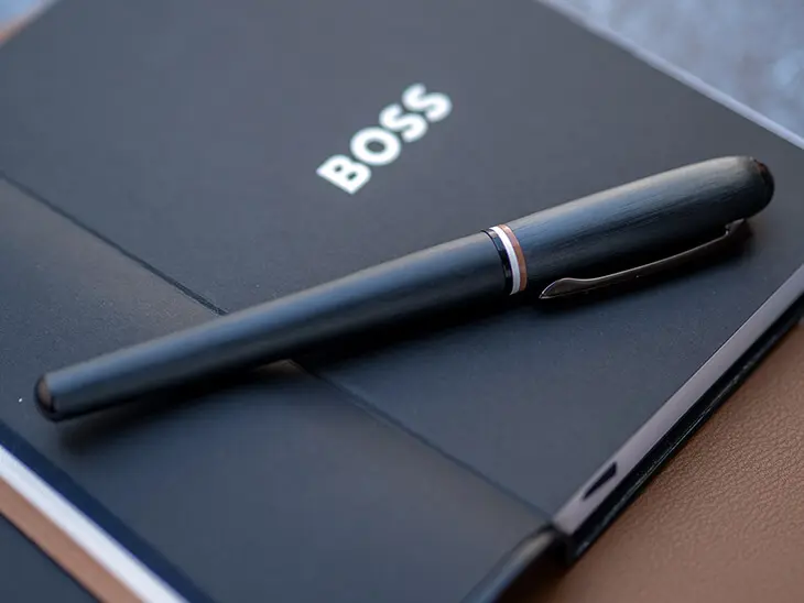 Schwarzer HUGO BOSS Füller liegt auf Notizbuch. Foto: Johanna Rundel