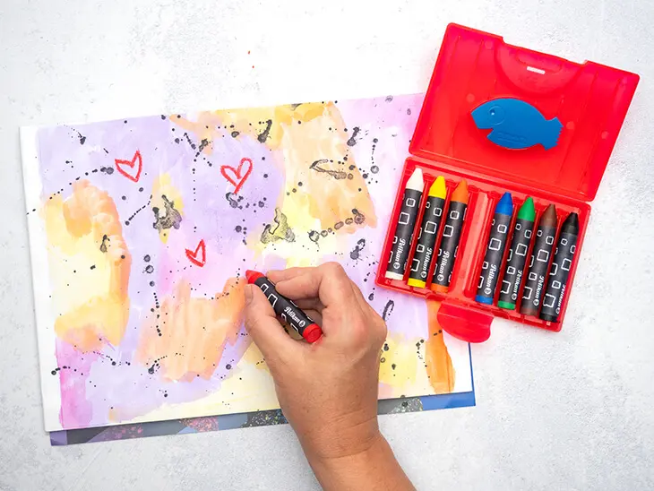 Jemand malt mit Pelikan-Wachsmalstiften auf Block. Foto: Johanna Rundel