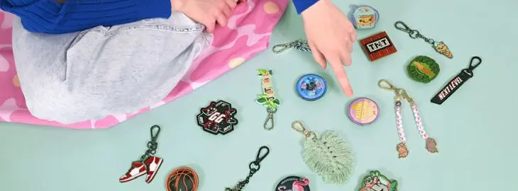 Eine Hand heftet einen COLOUR UP-Patch an einen Schulrucksack von coocazoo.