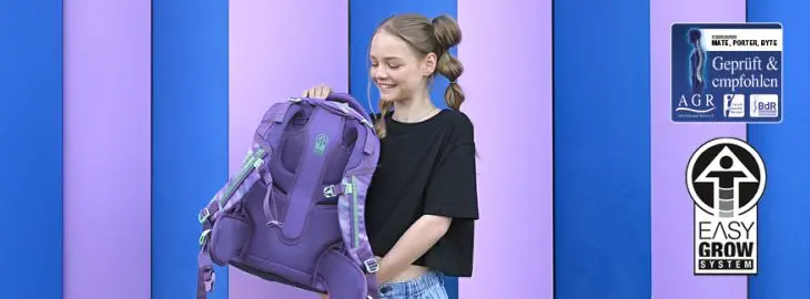 Ein Mädchen hält einen Schulrucksack von coocazoo hoch, daneben sind zwei Ergonomiesiegel eingebunden.