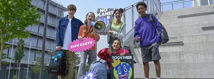 Vier Kinder mit Schulrucksäcken von coocazoo halten Schulder für mehr Klimaschutz in die Luft.