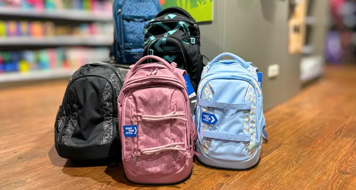 Vier Schulrucksäcke der Marken satch und coocazoo stehen auf dem Boden