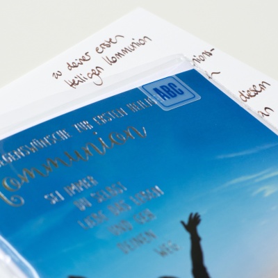 Nahaufnahmen Glückwunschkarte und handgeschriebener Text zur ersten heiligen Kommunion.