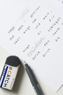 Handgeschriebener Segensspruch mit Stift und Radiergummi auf einem weißen Blatt Papier.