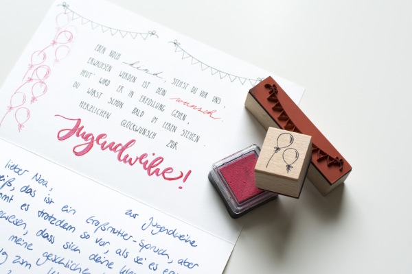 Handgeschriebene Glückwunschkarte zur Jugendweihe mit Stempeln und rotem Stempelkissen.