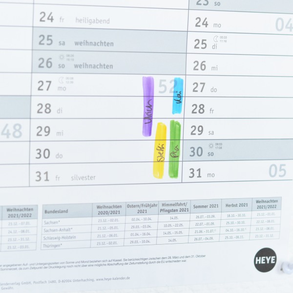 Detailaufnahme eines Kalenders, wo farbliche Markierungen für 4 Personen eingetragen sind.