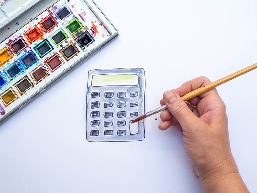 Jemand möchte Foto-Props für die Einschulung basteln und malt dafür eine gezeichnete Vorlage in Form eines Taschenrechners aus Papier mit Aquarellfarben aus. Foto: Johanna Rundel