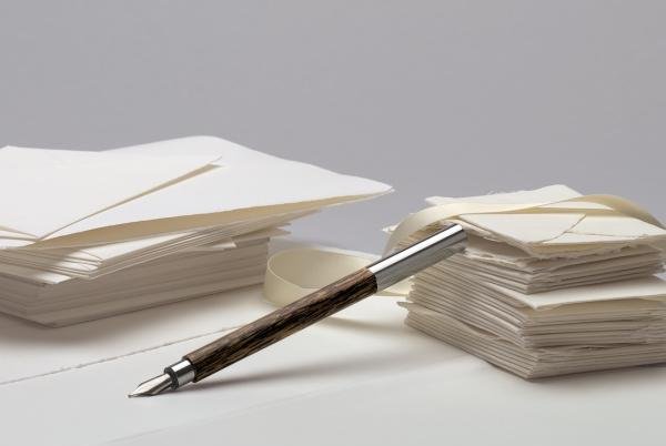Ein Faber-Castel Ambition Cocos Füllhalter liegt neben einem Stapel Bütten-Briefpapier und Umschlägen.