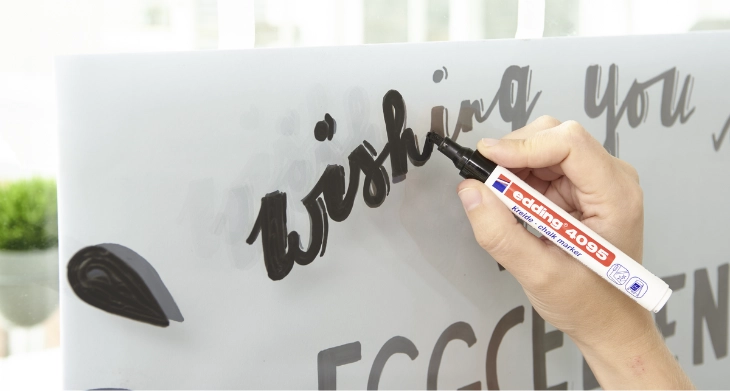 Auf dem Fenster wird mit einer Schablone gemalt.