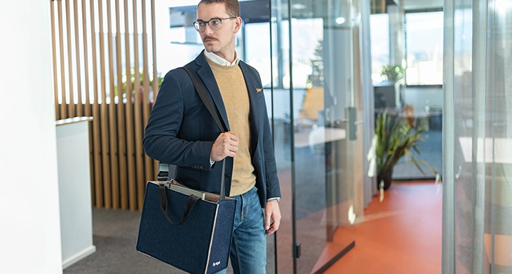 Ein Mann trägt die Bicolor Tasche über der Schulter.