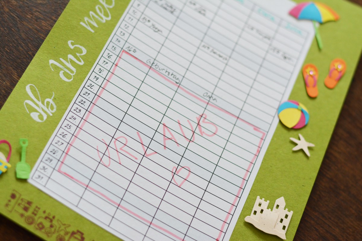 Urlaubszeit im Planer rot markiert, dekoriert mit Sommer-Stickern.