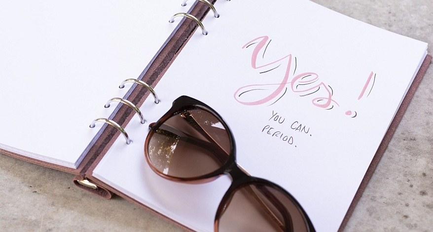 Notizbuch mit der handgeschriebenem Text und Sonnenbrille.