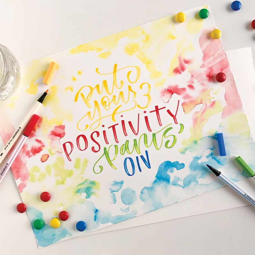 Bunt gestaltete und geletterte Karte, darauf liegen Stabilo Fineliner.