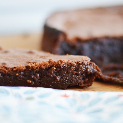 Ein Close-up von mehreren Stücken Schokoladenkuchen. Im Vordergrund ist unscharf eine geblümte Serviette zu sehen.