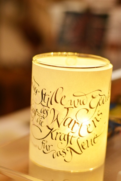 Ein Windlicht mit Kalligrafie belettert.